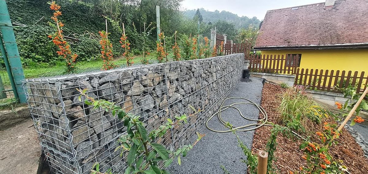 Gabionová zeď podél štěrkové cesty s novou výsadbou