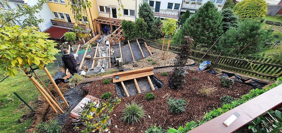 Realizace zahrady ve svahu – pergola, terasa a mulčované záhony s novou výsadbou
